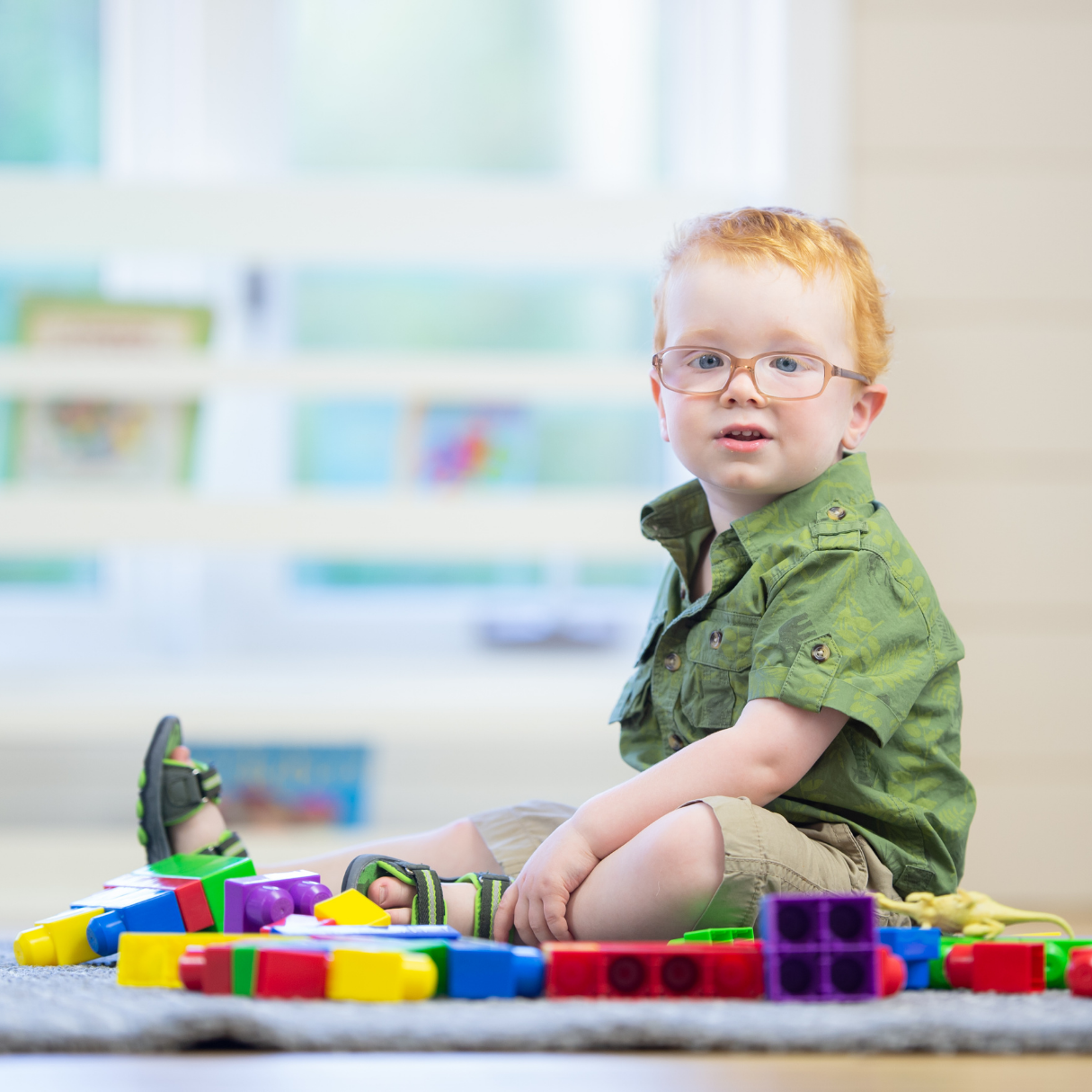 Child playing with colorful building blocks in a classroom setting