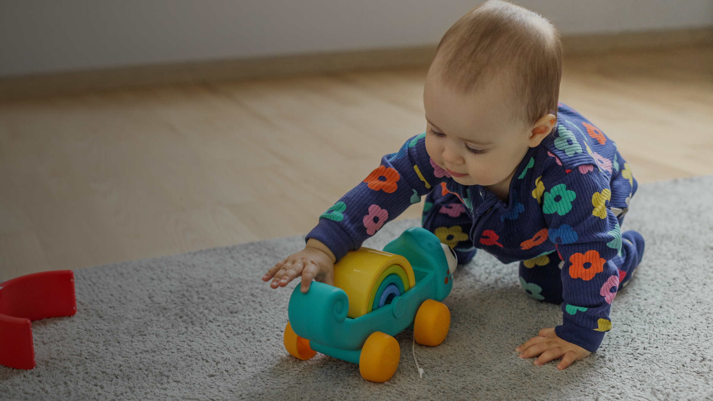 Baby playing with a toy on a carpeted floor